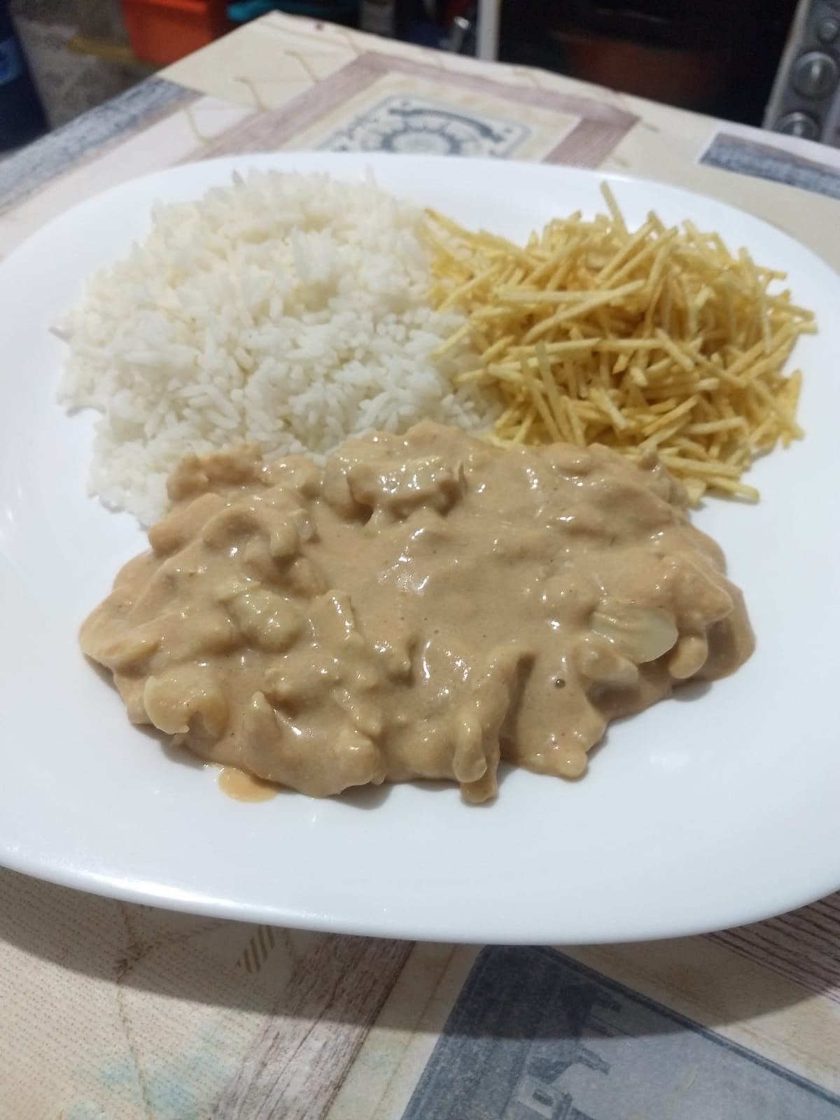 Refeição com arroz, molho e batata palha